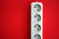 White electrical multi plug extender with european socket on bright red background