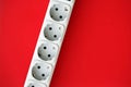 White electrical multi plug extender with european socket on bright red background