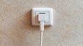 White Electrical Outlet with Plug on Light Textured Wall Surface Royalty Free Stock Photo
