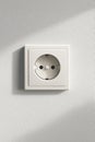 White electrical outlet, standard European Schuko type, mounted on textured white wall Royalty Free Stock Photo