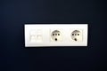 White electrical outlets on a blue wall with Internet connectors Royalty Free Stock Photo