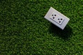 The white electrical plug socket on the green grass. Royalty Free Stock Photo