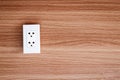 The white electrical plug socket  on a wooden wall. Royalty Free Stock Photo