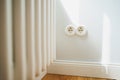 a white electricity socket on a white wall