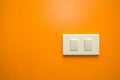 White electricity switch on orange wall background Royalty Free Stock Photo