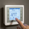 White electronic thermostat mounted on a gray wall showing a temperature setting of Royalty Free Stock Photo