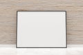 White empty blank picture or poster frame template mock up design standing on wooden floor with brick wall background in room with Royalty Free Stock Photo
