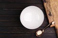 White empty bowl and spoon placed on black wooden table with top view copy space Royalty Free Stock Photo