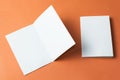 White empty brochure on orange background to replace your design. Mockup