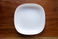 White empty ceramic plates on wooden table Royalty Free Stock Photo