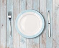 White empty dinner plate with blue border on wooden table Royalty Free Stock Photo