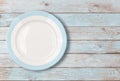 White empty dinner plate with blue border on wooden table Royalty Free Stock Photo