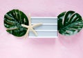 White empty lightbox, monstera leaf, starfish on pink background. Summer fashion flat lay. Vacation, travel concept. Top view Royalty Free Stock Photo