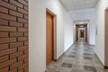 white empty long corridor with red brick walls in interior of modern apartments, office or clinic Royalty Free Stock Photo