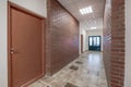 white empty long corridor with red brick walls in interior of modern apartments, office or clinic Royalty Free Stock Photo