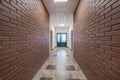 white empty long corridor with red brick walls in interior of modern apartments, office or clinic Royalty Free Stock Photo