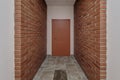 white empty long corridor with red brick walls for room office in interior of modern apartments, office or clinic Royalty Free Stock Photo