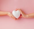 White empty love heart in hands on pink background