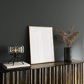 White empty mockup picture frame on wooden console with dry plant decoration and glass table lamp Royalty Free Stock Photo