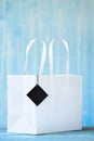 White empty paper shopping bag with blank hang tag. Sale, buying, shopping mock up with free copy sapce