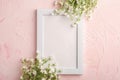 White empty photo frame mockup with mouse-ear chickweed flowers on pink textured background Royalty Free Stock Photo