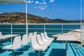 White empty plastic fiberglass chairs and seating area with tables on a ferry boat under a bright summer sky Royalty Free Stock Photo