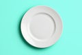 White empty plate on mint background close-up top view. Royalty Free Stock Photo