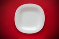 White empty plate on a red background with vignetting top view flat lay