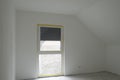 White empty ready-to-paint room with attic ceiling,French window,concrete floor.Roller shutter is third down.Copy space Royalty Free Stock Photo