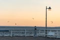 white empty wooden bench on pier by sea or ocean water, tranquility and serenity concept, calm sunset scene Royalty Free Stock Photo