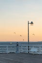 white empty wooden bench on pier by sea or ocean water, tranquility and serenity concept, calm sunset scene Royalty Free Stock Photo