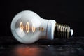 White energy saving bulb shines against sleek black background dramatically Royalty Free Stock Photo