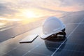 White engineer hard hat and a tablet placed on the solar panel At a photovoltaic power station working on solar energy storage in