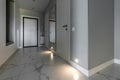 White entrance door inside the apartment in a modern interior. LED backlighting in the wall