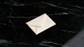 A white envelope on a black marble countertop. Royalty Free Stock Photo