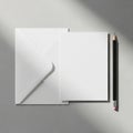 White envelope and blank sheet of paper on a light gray textured surface. Positioned Royalty Free Stock Photo