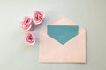 white envelope, blue blank card, three pink rose flowers on a blue background. Minimal Flat lay Royalty Free Stock Photo