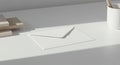 White envelope placed on a white table in a minimalist setting. To the left, a small stac Royalty Free Stock Photo