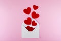 White envelope and red paper hearts on pink background. Valentine`s day, love, anniversary concept Royalty Free Stock Photo