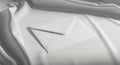 A white envelope rests on a smooth, flowing white fabric surface. The envelope is Royalty Free Stock Photo