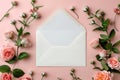 white envelope sits on a pink background with flowers. envelope is open and empty and flowers are scattered around it. Concept of Royalty Free Stock Photo
