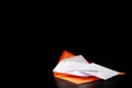 White envelopes fall on the orange envelope on top. Orange envelope lies on a black background. White and orange envelopes on a bl