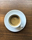 White espresso cup on wooden table top down view Royalty Free Stock Photo