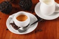 White espresso coffee Cup, coffee beans and milk jug on wooden background. Concept of coffee breaks and serving coffee Royalty Free Stock Photo