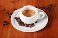 White espresso coffee Cup closeup, roasted coffee beans on wooden background. Concept of coffee break and serving coffee Royalty Free Stock Photo