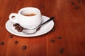 White espresso coffee Cup closeup, roasted coffee beans on wooden background. Concept of coffee break and serving coffee Royalty Free Stock Photo