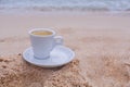 White espresso coffee cup on the sand in the morning day Royalty Free Stock Photo