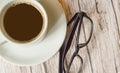 White espresso Cup and black stylish glasses on wooden background, top view, business concept pause