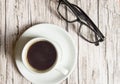 White espresso Cup and black stylish glasses on wooden background, top view, business concept pause Royalty Free Stock Photo