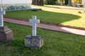 White even cross made of marble on the green lawn of the cemetery Royalty Free Stock Photo